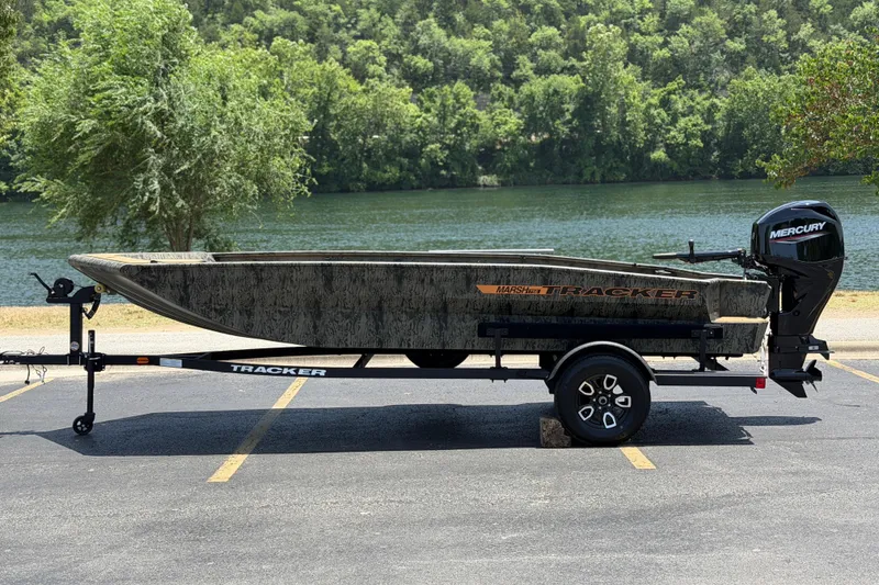 The Image of 2026 Tracker Grizzly 1756 T Marsh boat on trailer by a scenic river. - 0