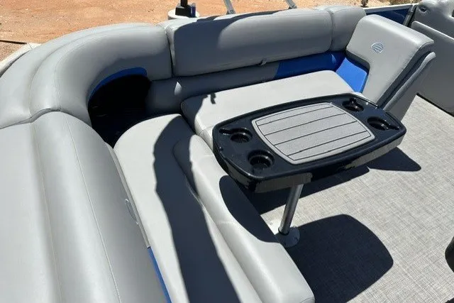 Slide: The Image of 2026 Sun Tracker Party Barge 20 DLX interior with gray seating and table. - 13