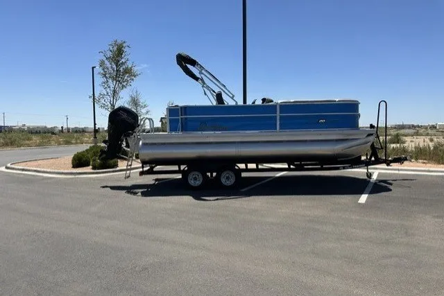 Slide: The Image of 2026 Sun Tracker Party Barge 20 DLX pontoon boat on trailer in parking lot. - 16