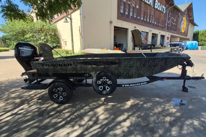 Slide: The Image of 2026 Tracker Grizzly 1650 T Prairie Wings Edition boat on trailer, parked outside a store. - 4