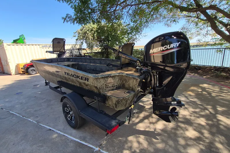 Slide: The Image of 2026 Tracker Grizzly 1650 T Prairie Wings Edition boat with Mercury engine, parked outdoors. - 7