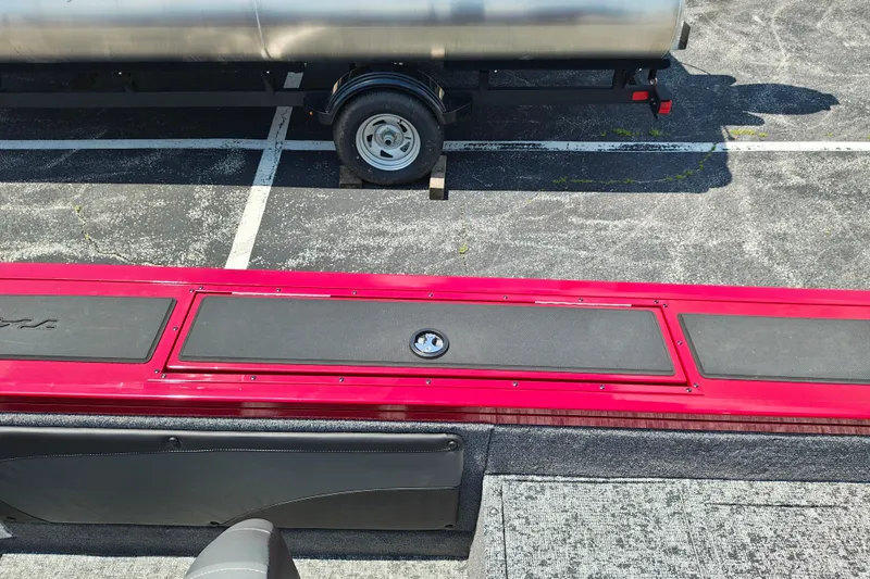 Slide: The Image of 2026 Tracker Targa V-19 WT boat interior with red and black detailing, parked on asphalt. - 7