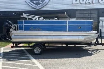 The Image of 2026 Sun Tracker Party Barge 18 DLX pontoon boat on trailer, parked outside dealership. - 0
