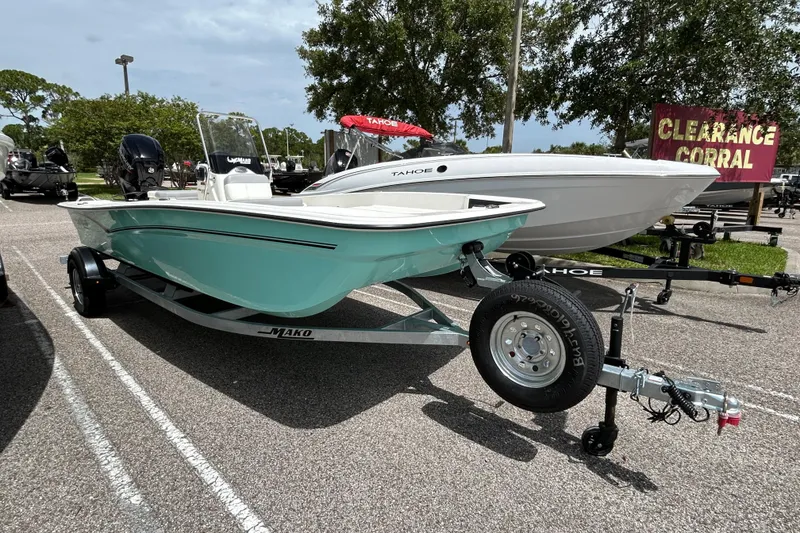 The Image of 2026 Mako Pro Skiff 17 CC boat on trailer in parking lot, clearance sale sign visible. - 0