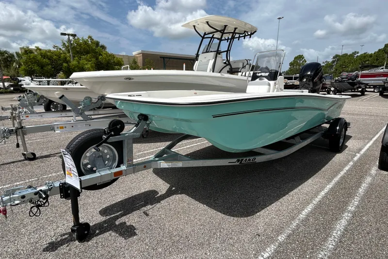 Slide: The Image of 2026 Mako Pro Skiff 17 CC boat on trailer, parked outdoors under a cloudy sky. - 1