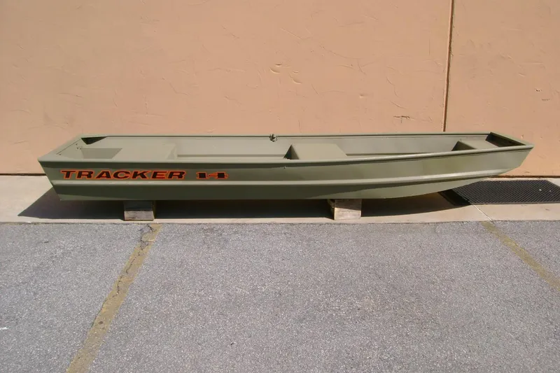 The Image of 2026 Tracker Grizzly 14 Jon boat displayed outdoors on wooden blocks. - 0