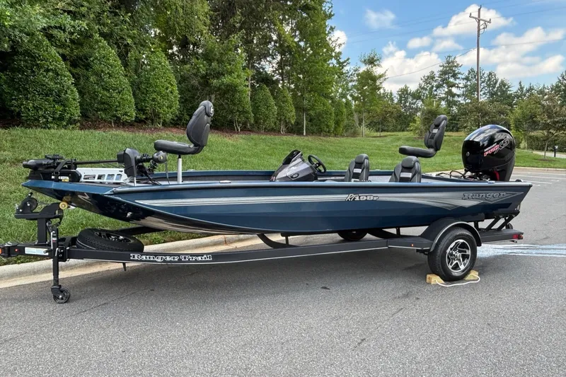 Slide: The Image of 2026 Ranger RT198P boat on trailer, parked on road with lush greenery background. - 1