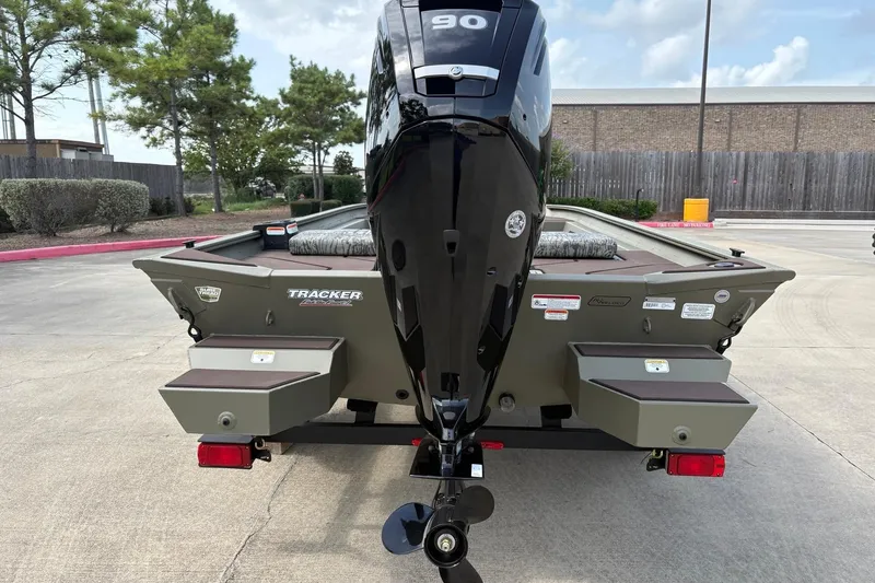 Slide: The Image of 2026 Tracker Grizzly 1860 CC boat with powerful outboard motor, parked outdoors. - 3