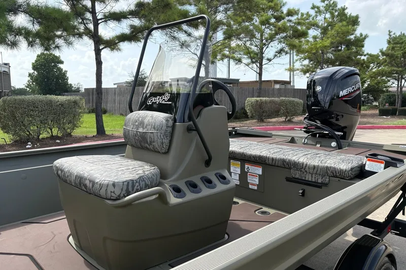 Slide: The Image of 2026 Tracker Grizzly 1860 CC boat interior with Mercury engine, camo seats, and console. - 4