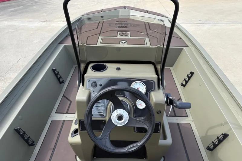Slide: The Image of 2026 Tracker Grizzly 1860 CC boat interior with steering wheel and control panel. - 5
