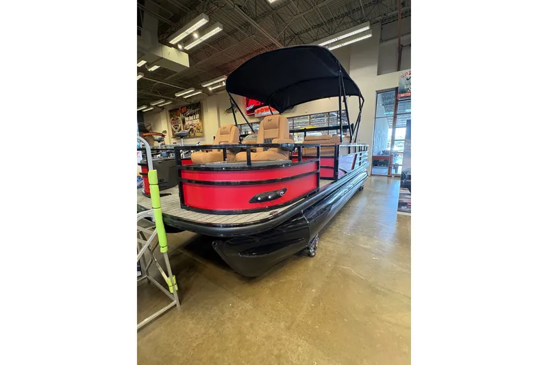 Slide: The Image of 2026 Ranger 223FC pontoon boat with red exterior and black canopy in showroom. - 6