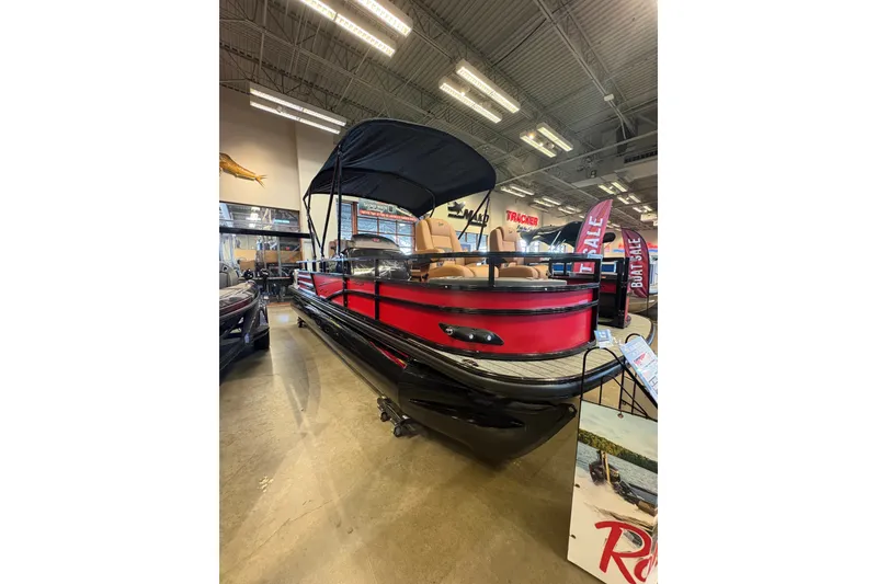 Slide: The Image of 2026 Ranger 223FC pontoon boat on display in showroom with sale banners. - 2