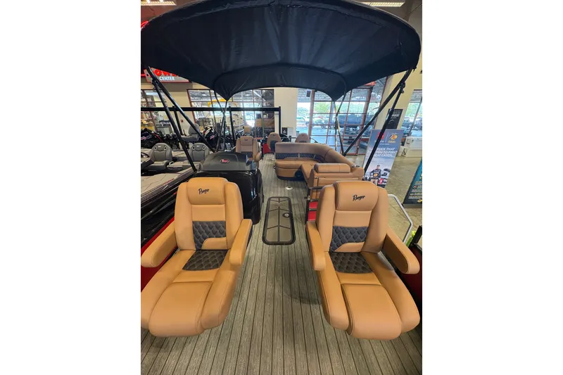 Slide: The Image of 2026 Ranger 223FC boat interior with tan seating and canopy in showroom. - 36