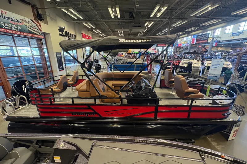The Image of 2026 Ranger 223FC pontoon boat with canopy, displayed indoors at a showroom. - 0