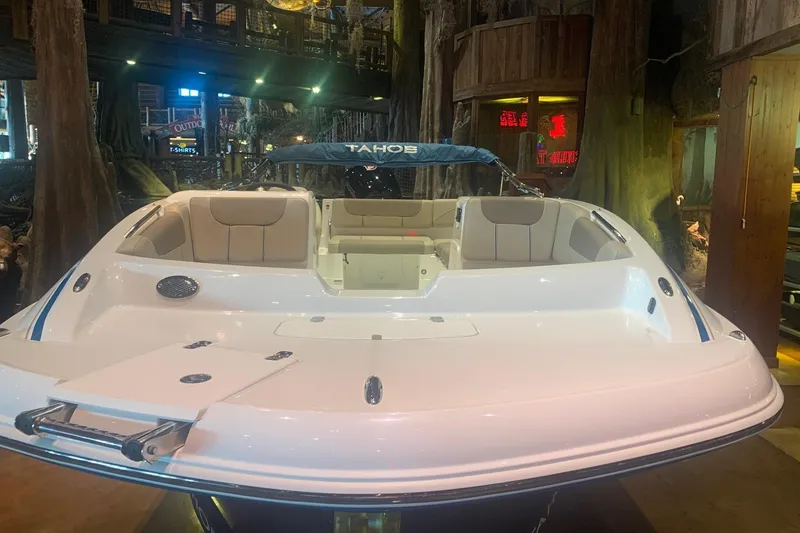Slide: The Image of 2026 Tahoe 1950 boat with sleek white design and spacious seating in showroom. - 2