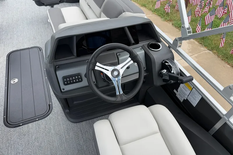 Slide: The Image of Steering console of 2026 Sun Tracker Fishin' Barge 22 XP3 with comfortable seating and control panel. - 19