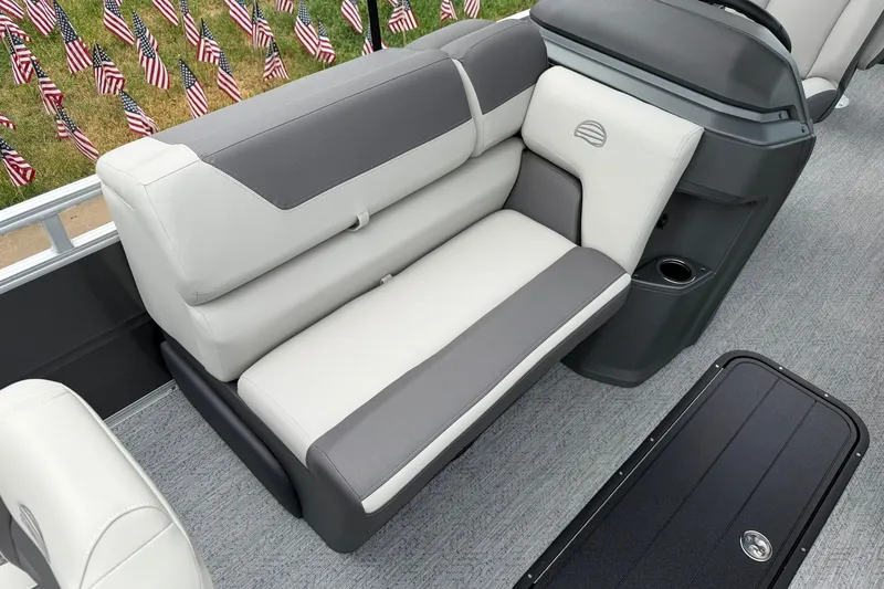 Slide: The Image of 2026 Sun Tracker Fishin' Barge 22 XP3 interior with comfortable seating and American flags in background. - 15