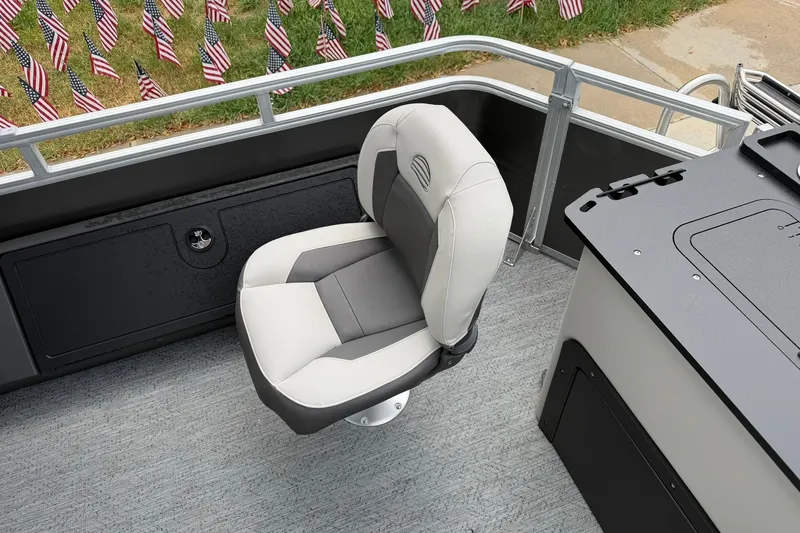 Slide: The Image of 2026 Sun Tracker Fishin' Barge 22 XP3 interior with swivel seat and American flags in background. - 26
