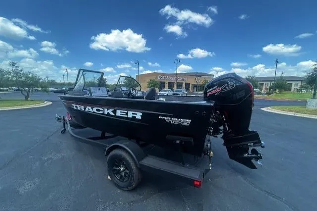 Slide: The Image of 2026 Tracker Pro Guide V-175 Combo boat on trailer, parked outdoors under a blue sky. - 2