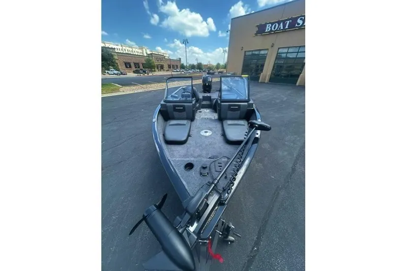 Slide: The Image of 2026 Tracker Pro Guide V-175 Combo boat displayed outside a dealership under a blue sky. - 4