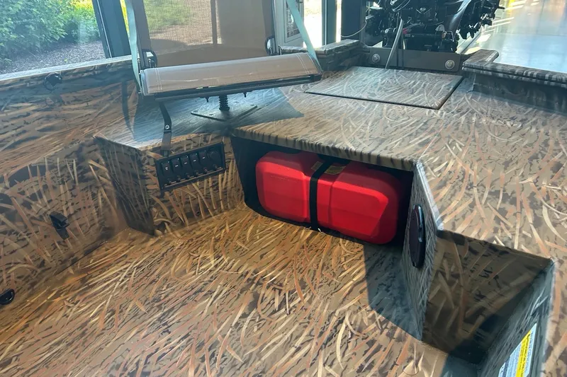 Slide: The Image of 2026 Tracker Grizzly 1650 T Prairie Wings Edition boat interior with camo design and red fuel tank. - 4