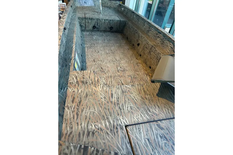 Slide: The Image of 2026 Tracker Grizzly 1650 T Prairie Wings Edition boat interior with camouflage design. - 2