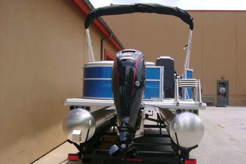 Slide: The Image of 2026 Sun Tracker Party Barge 20 DLX pontoon boat with outboard motor, parked outdoors. - 8