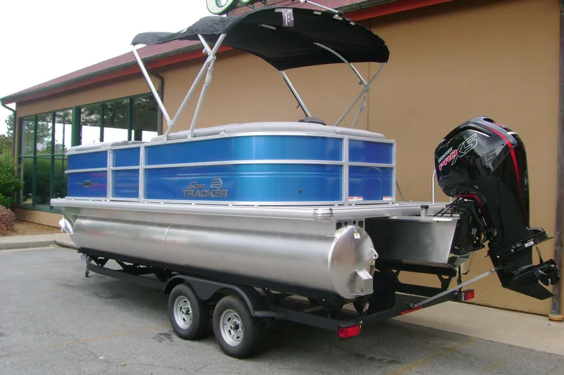 Slide: The Image of 2026 Sun Tracker Party Barge 20 DLX pontoon boat on trailer, parked outdoors. - 5