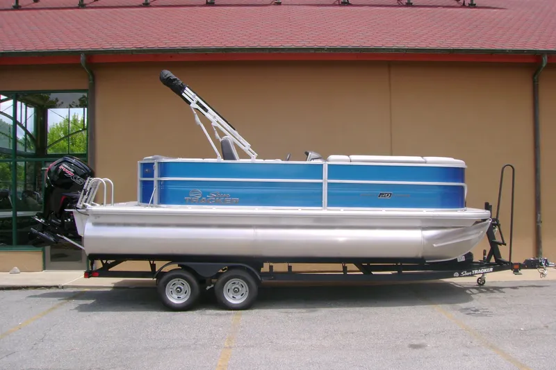 The Image of 2026 Sun Tracker Party Barge 20 DLX pontoon boat on trailer, parked outdoors. - 0