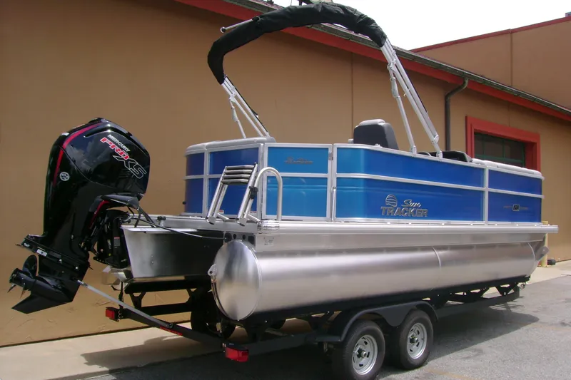 Slide: The Image of 2026 Sun Tracker Party Barge 20 DLX pontoon boat with outboard motor on trailer. - 4