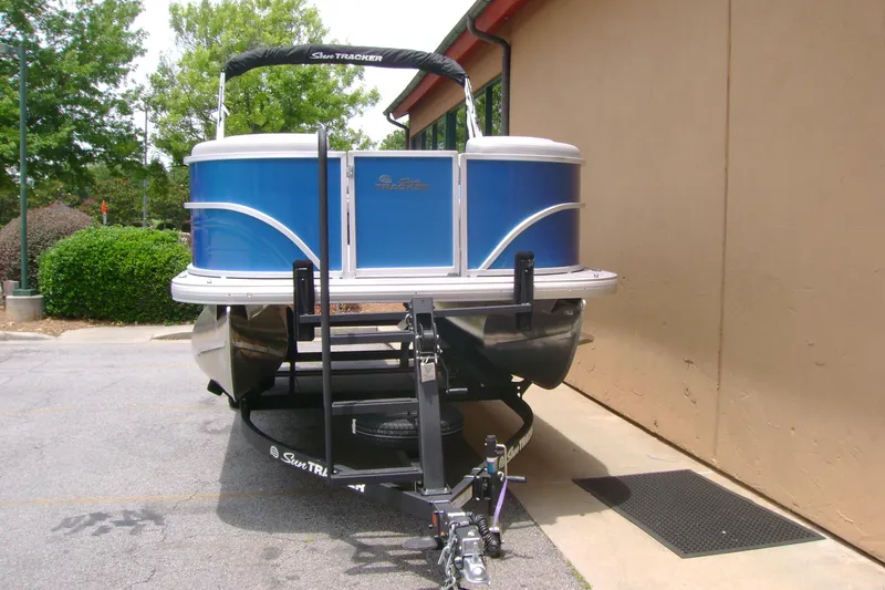 Slide: The Image of 2026 Sun Tracker Party Barge 20 DLX pontoon boat on trailer, parked outdoors. - 6