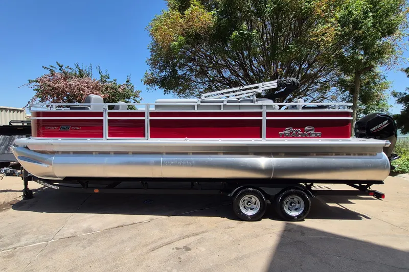 The Image of 2026 Sun Tracker Sportfish 24 XP3 pontoon boat on trailer, parked outdoors. - 0