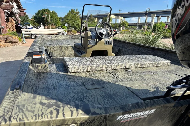Slide: The Image of 2026 Tracker Grizzly 2072 CC boat with camouflage design, parked outdoors. - 4