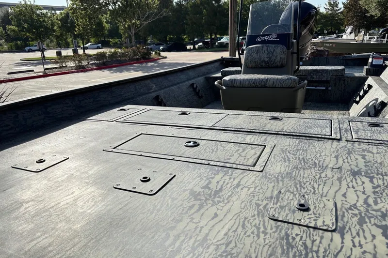 Slide: The Image of 2026 Tracker Grizzly 2072 CC boat with camo deck, parked outdoors. - 13