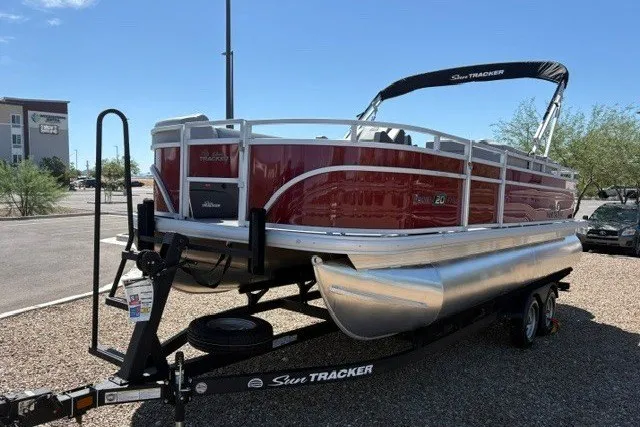 The Image of 2026 Sun Tracker SportFish 20 DLX pontoon boat on trailer, parked outdoors. - 0