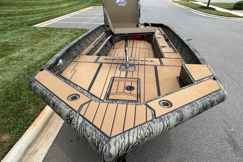 Slide: The Image of 2026 Tracker Grizzly 1756 T Marsh boat with camouflage design on a paved road. - 3