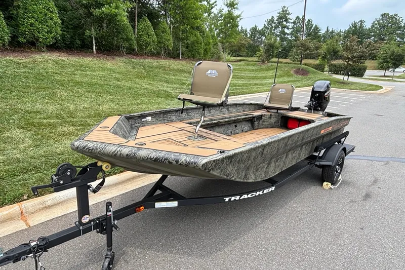 Slide: The Image of 2026 Tracker Grizzly 1756 T Marsh boat on trailer, parked outdoors. - 2