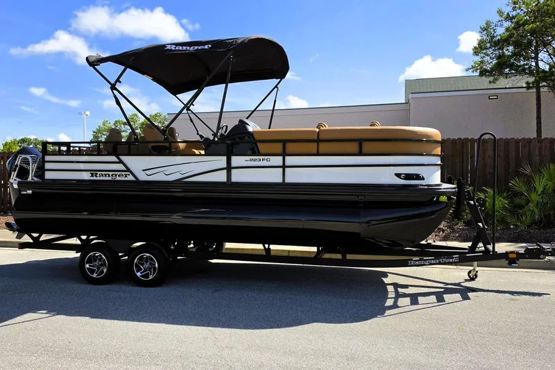 Slide: The Image of 2026 Ranger 223FC pontoon boat on trailer, featuring sleek design and canopy. - 6