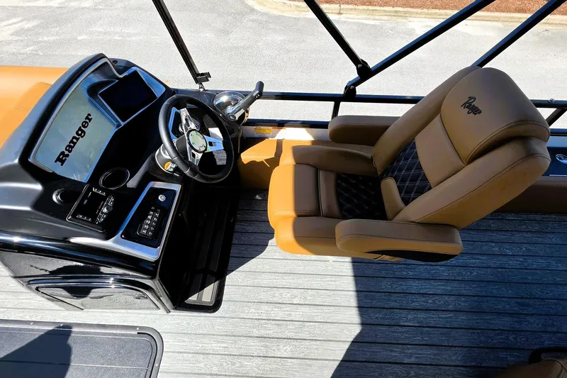 Slide: The Image of Captain's seat and helm of 2026 Ranger 223FC boat, featuring modern controls and luxurious seating. - 14