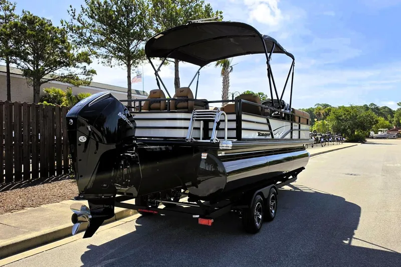 Slide: The Image of 2026 Ranger 223FC pontoon boat on trailer, parked outdoors under clear sky. - 4