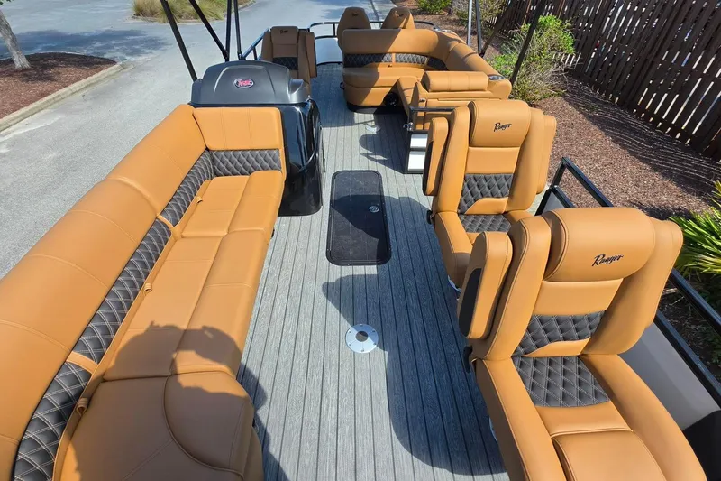 Slide: The Image of Luxurious 2026 Ranger 223FC boat interior with tan and black seating, docked outdoors. - 16