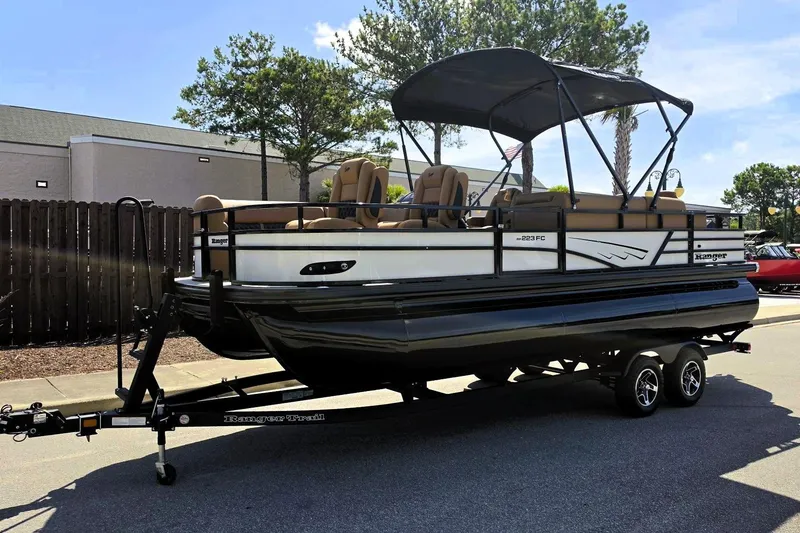 Slide: The Image of 2026 Ranger 223FC pontoon boat on trailer, featuring sleek design and comfortable seating. - 11