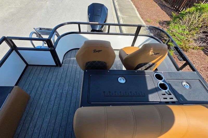 Slide: The Image of 2026 Ranger 223FC boat interior with tan seats and black console, featuring cup holders. - 19