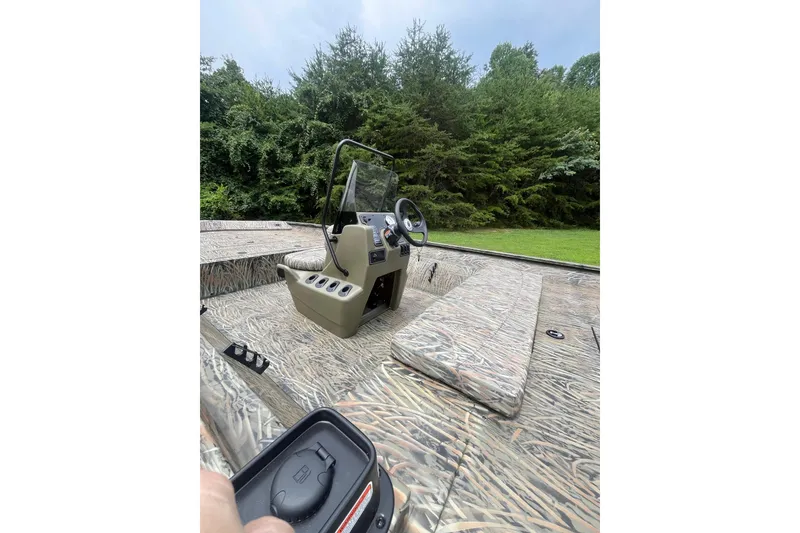 Slide: The Image of 2026 Tracker Grizzly 2072 CC boat interior with camouflage design and steering console. - 3