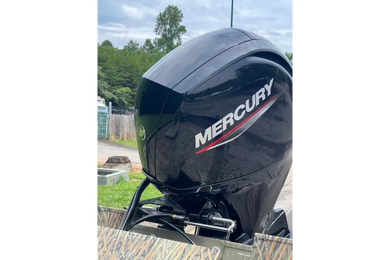 Slide: The Image of Mercury outboard motor on 2026 Tracker Grizzly 2072 CC boat, outdoors. - 2