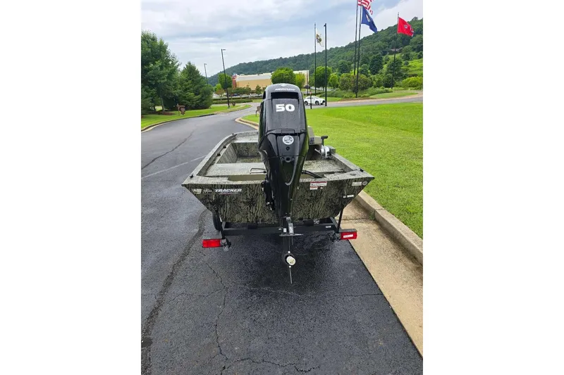 Slide: The Image of 2026 Tracker Grizzly 1648 SC boat with 50 HP motor on a paved road. - 4