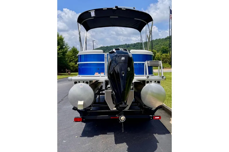 Slide: The Image of 2026 Sun Tracker Party Barge 22 XP3 pontoon boat with outboard motor, parked outdoors. - 5