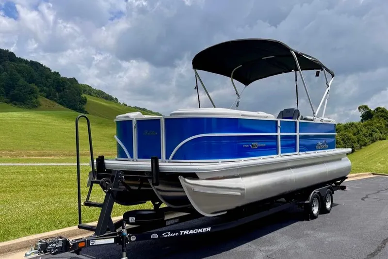 Slide: The Image of 2026 Sun Tracker Party Barge 22 XP3 pontoon boat on trailer, scenic background. - 3