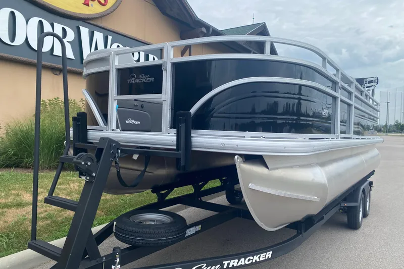 Slide: The Image of 2026 Sun Tracker SportFish 20 DLX pontoon boat on trailer, parked outside store. - 4