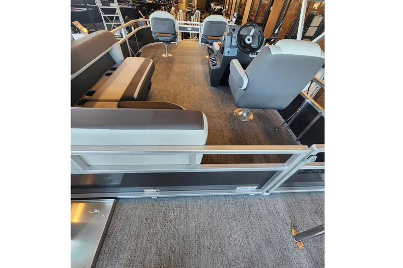 Slide: The Image of Interior of 2026 Sun Tracker Bass Buggy 16 XL Select pontoon boat with seating and steering console. - 2